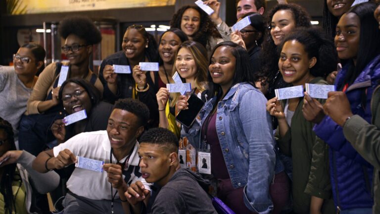 Group of diverse students holding tickets, excited about "Giving Voice.