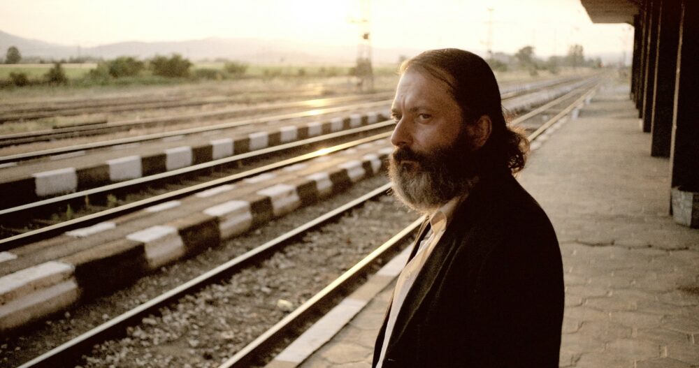 Man with beard at train station.