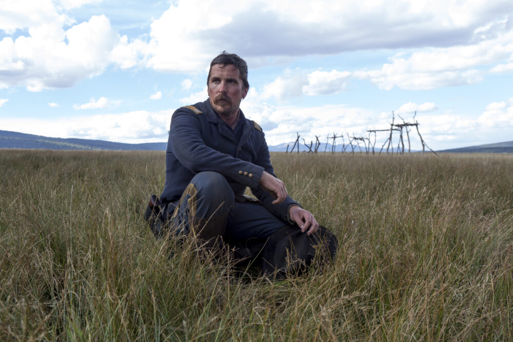 Christian Bale in "Hostiles" kneeling in a field.