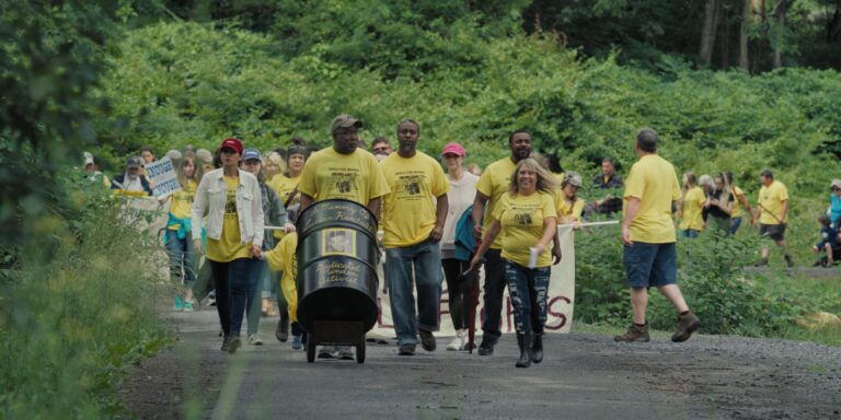 People marching for Minden, holding a barrel with "In Memory Of Lucian Randale" text.