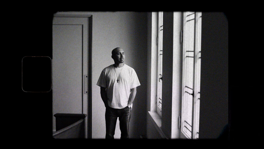 Pensive man looking out window. Inthrive: Incarceration Survivors’ Voices.