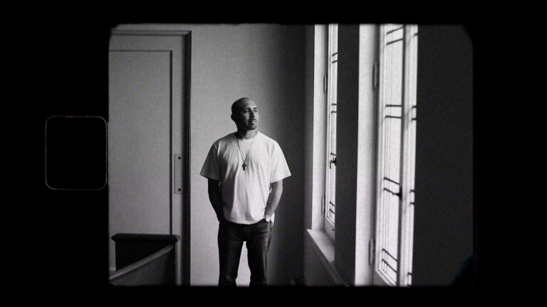 Pensive man looking out window. Inthrive: Incarceration Survivors’ Voices.