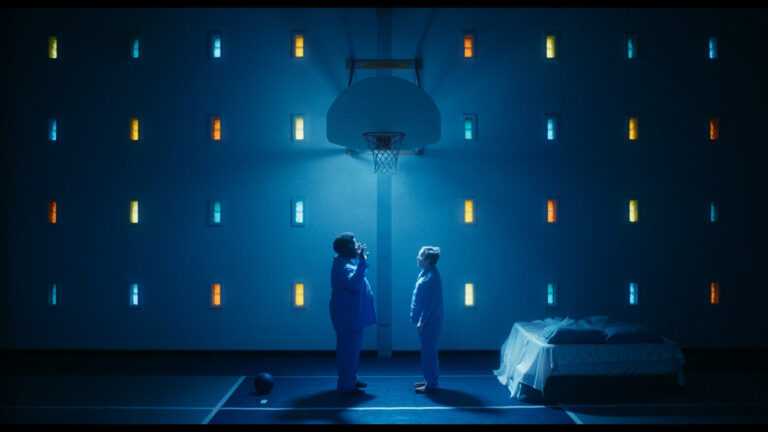Two figures in blue stand in a surreal basketball court setting.