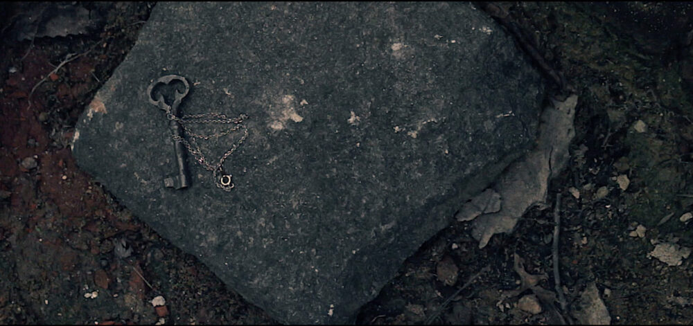 Antique key and necklace on a stone, possibly related to "Incubus.