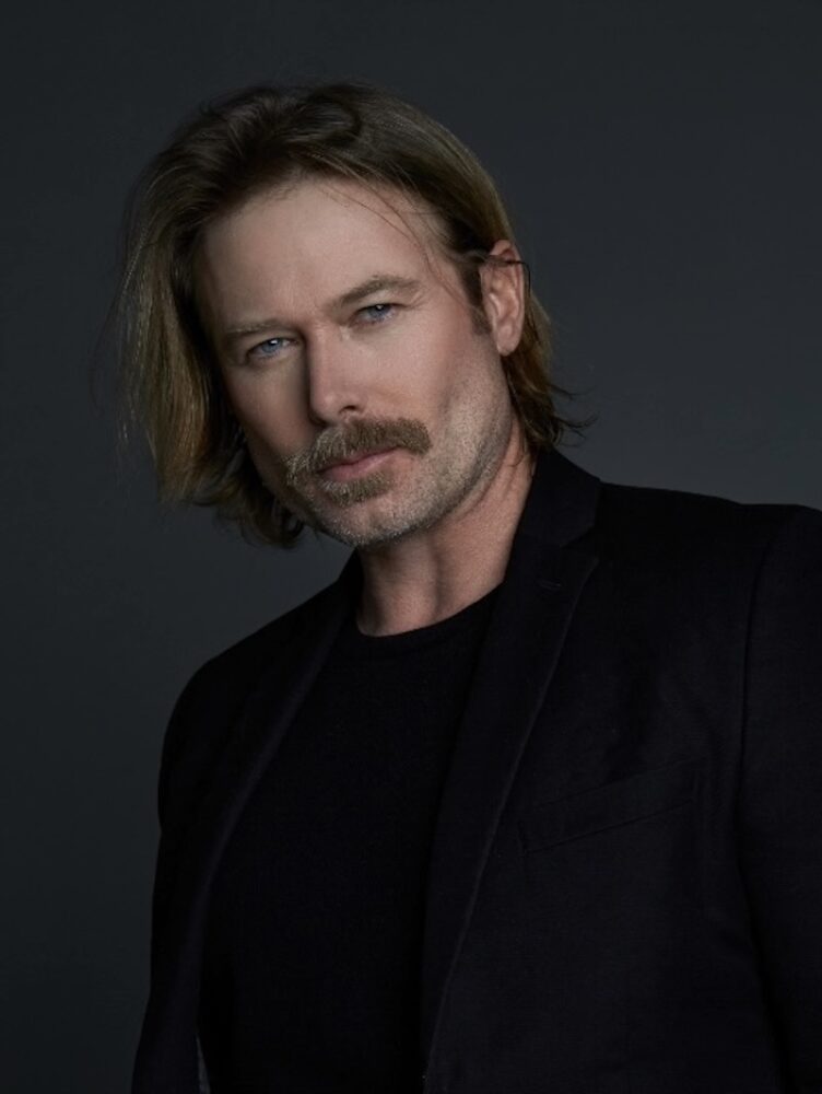 Jacob Young portrait with a mustache, wearing a black suit.
