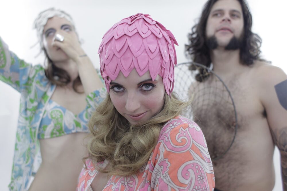 Quirky group photo with woman in pink hat, promoting "Karate Tango"