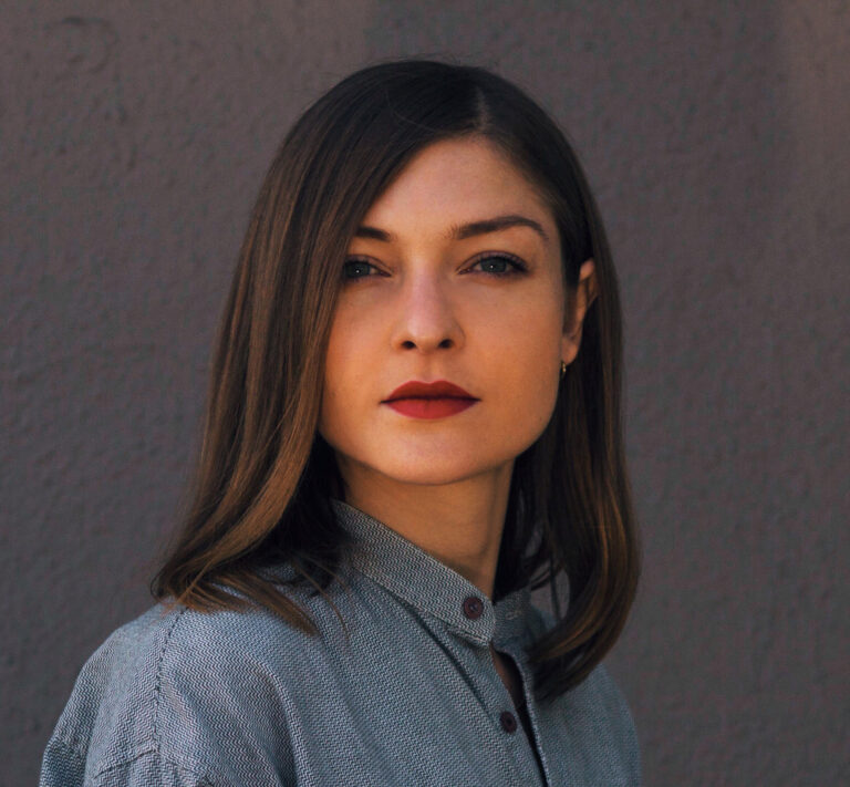 Katherine St.Paul Hill portrait; headshot of a woman with shoulder-length brown hair and red lipstick.