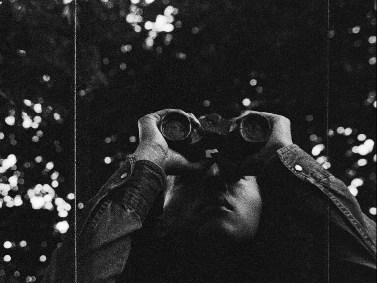 Person with binoculars looking up.