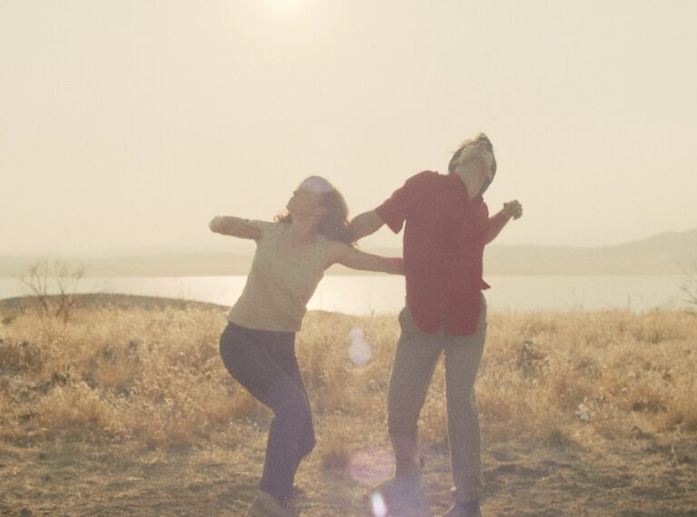 Couple dancing outdoors near a lake, enjoying the freedom like "The Wind and the Kite.