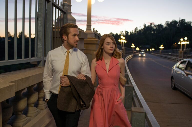 Ryan Gosling and Emma Stone in La La Land walking on a bridge