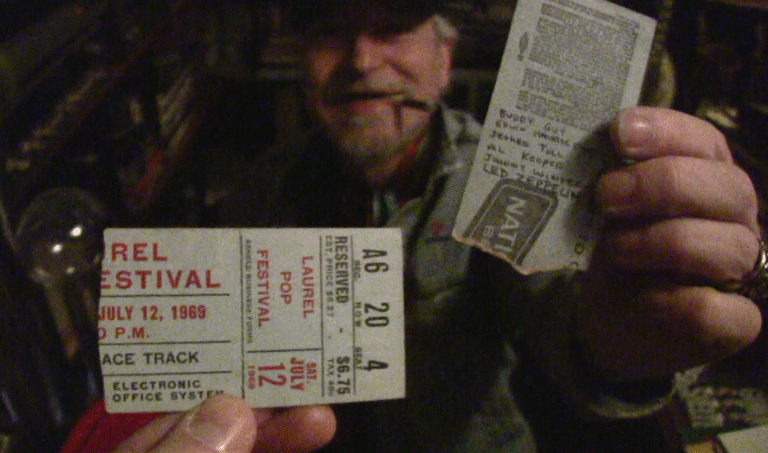 A man holding a Laurel Pop Festival ticket, July 12, 1969, featuring Led Zeppelin.