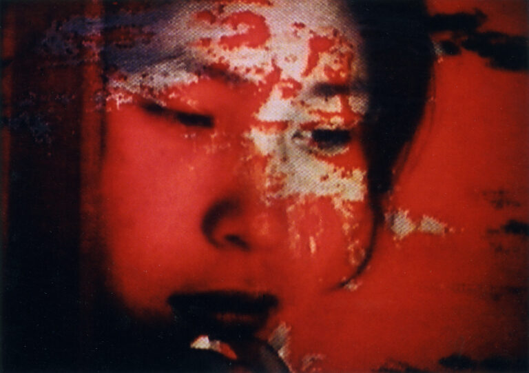 Distorted portrait of a face in red tones.