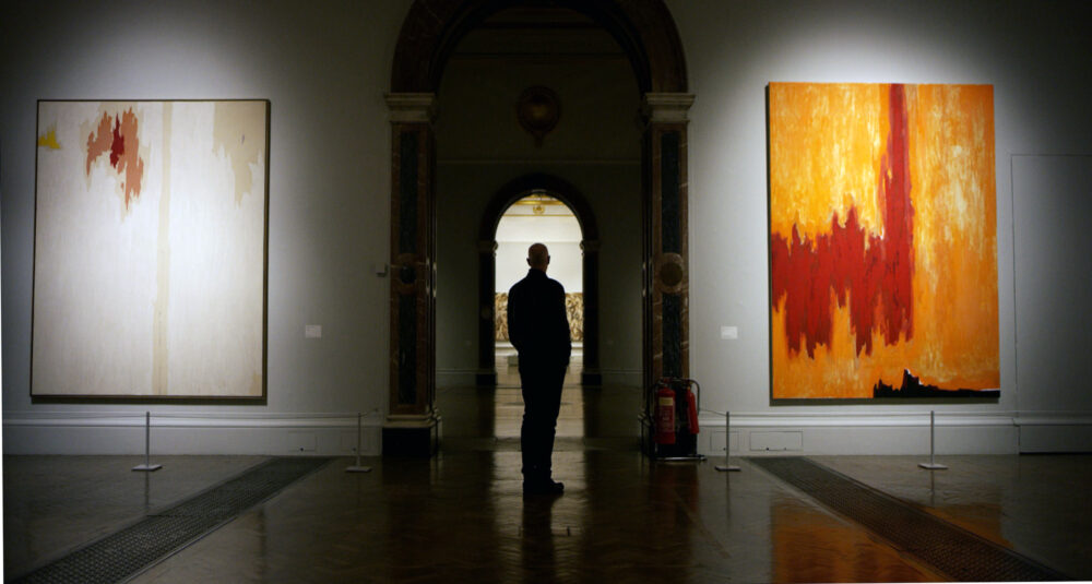 Man viewing abstract art in a museum gallery.