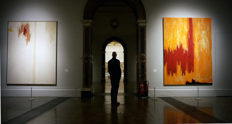 Man viewing abstract art in a museum gallery.