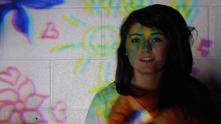 Woman with colorful light projections.