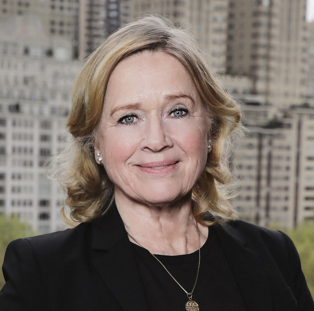 Portrait of Liv Ullmann, actress and director, in front of a city backdrop.