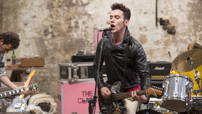 London Town: A band performs live on stage in a raw, industrial setting.