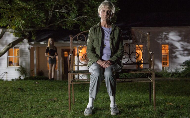 Elderly woman on bench at night, young girl stands near house. "The Looking Glass" mystery.