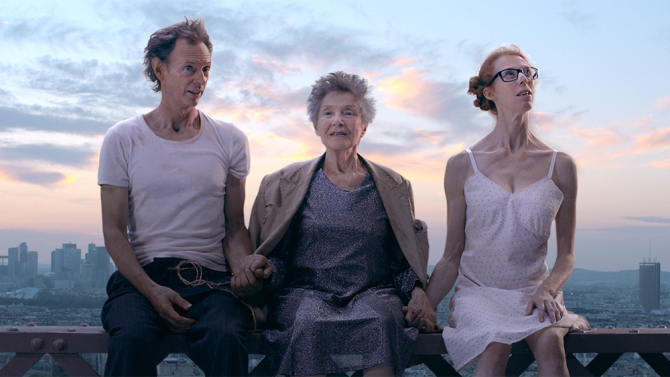 Three quirky characters on a bridge overlooking Paris.