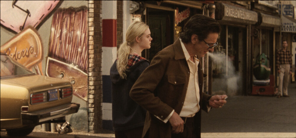Elle Fanning and John Hawkes in "Low Down" movie scene on a city street.