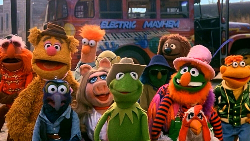 The Muppets pose in front of the Electric Mayhem bus from The Muppet Movie.