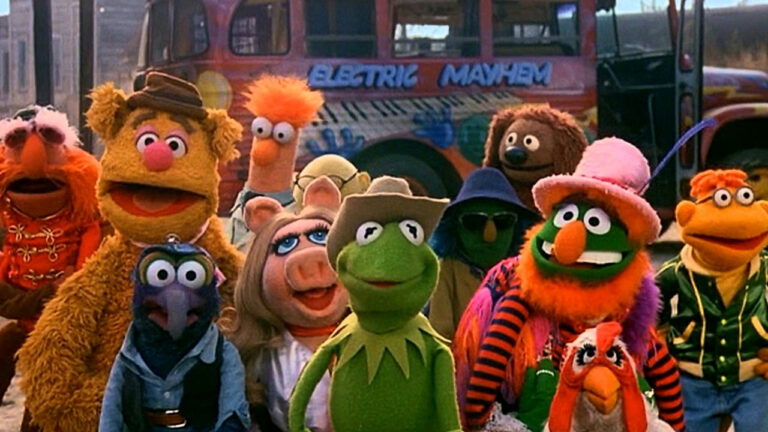 The Muppets pose in front of the Electric Mayhem bus from The Muppet Movie.