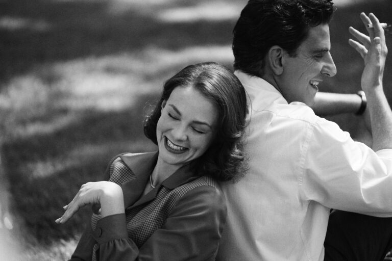 Carey Mulligan and Bradley Cooper laughing in "Maestro" movie still.