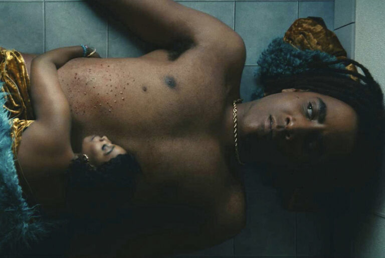 I'm a Virgo: Jharrel Jerome and Olivia Washington lie on a tiled floor, close together, wearing velvet and gold.