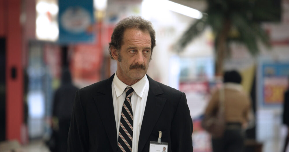 Man in suit with name tag in shopping center.