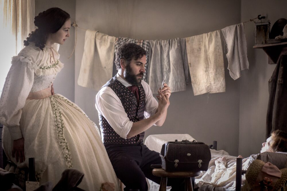 Man with syringe, woman in dress, "Mercy Street" scene