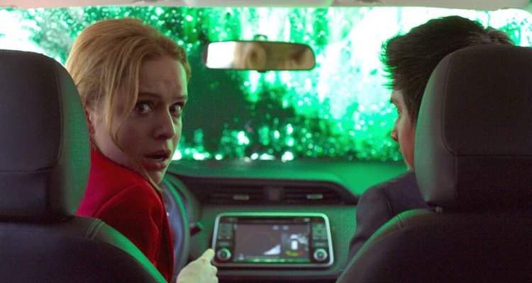 Woman in car looking shocked, with a man beside her.