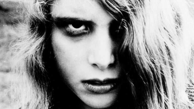 Karen, a zombie from "Night of the Living Dead," stares intensely with dark eyes and disheveled hair.