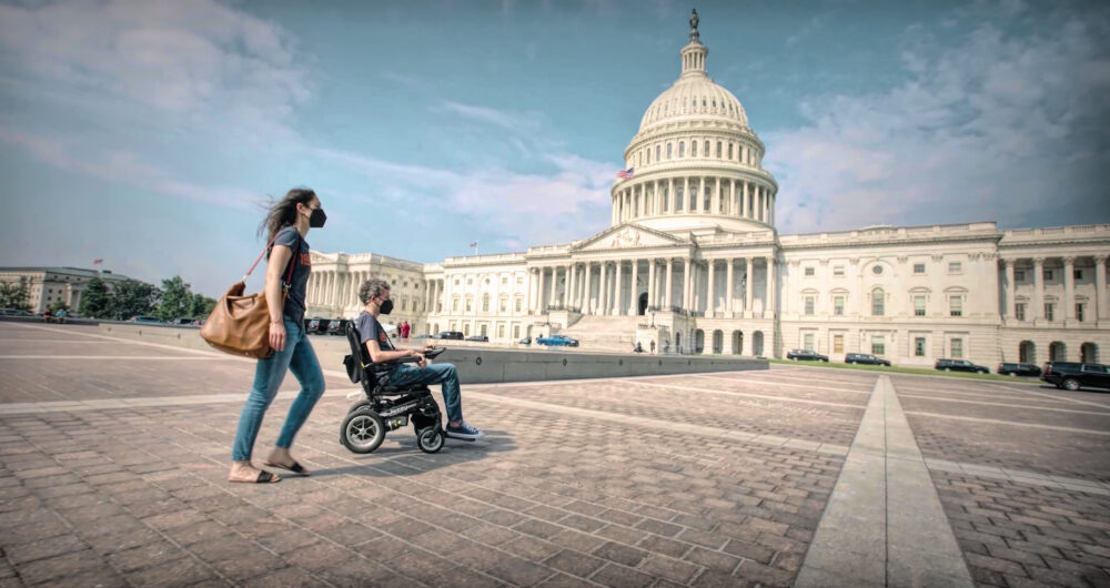 Person in wheelchair and companion visit the US Capitol Building.