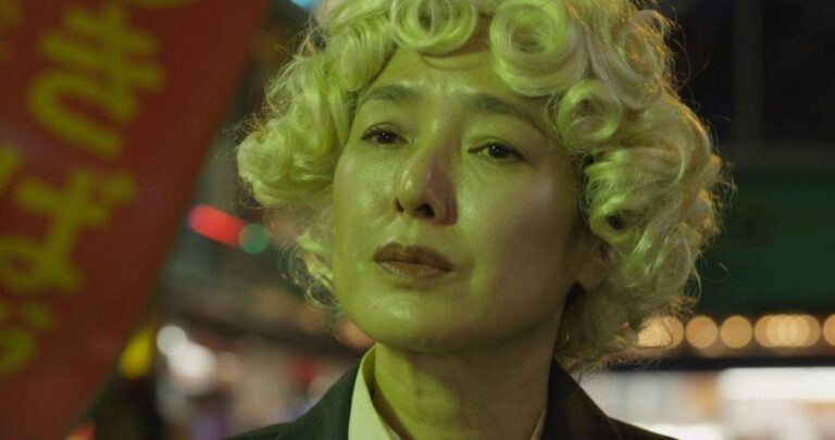 Japanese actress Shinobu Terajima in "Oh Lucy!" with curly blonde hair and a serious expression.