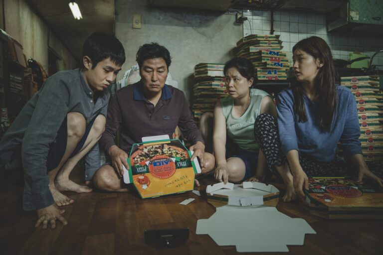 The Kim family folding pizza boxes in the movie Parasite.