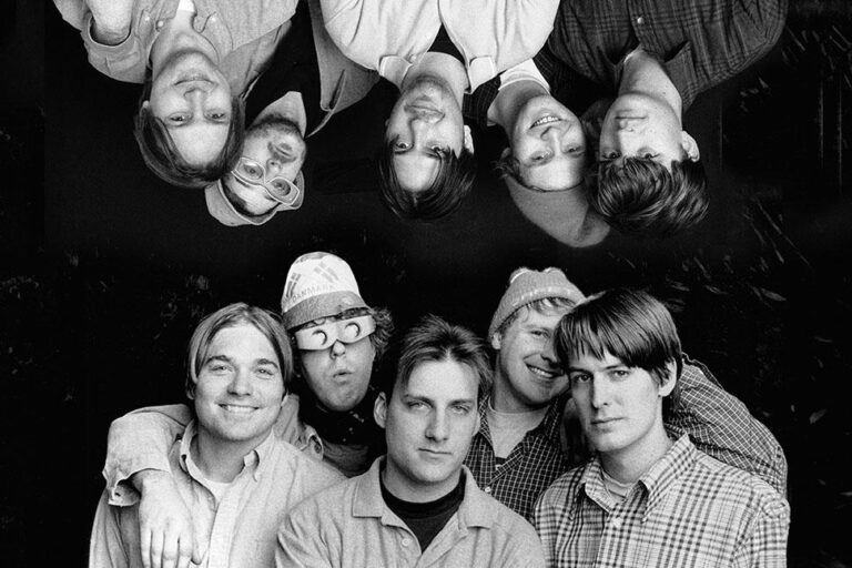 Pavement band portrait, black and white. Indie rock group shot with reflection effect.
