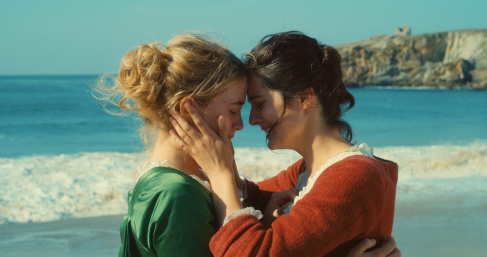 Portrait of a Lady on Fire: Marianne and Héloïse embrace on the beach, a tender moment.