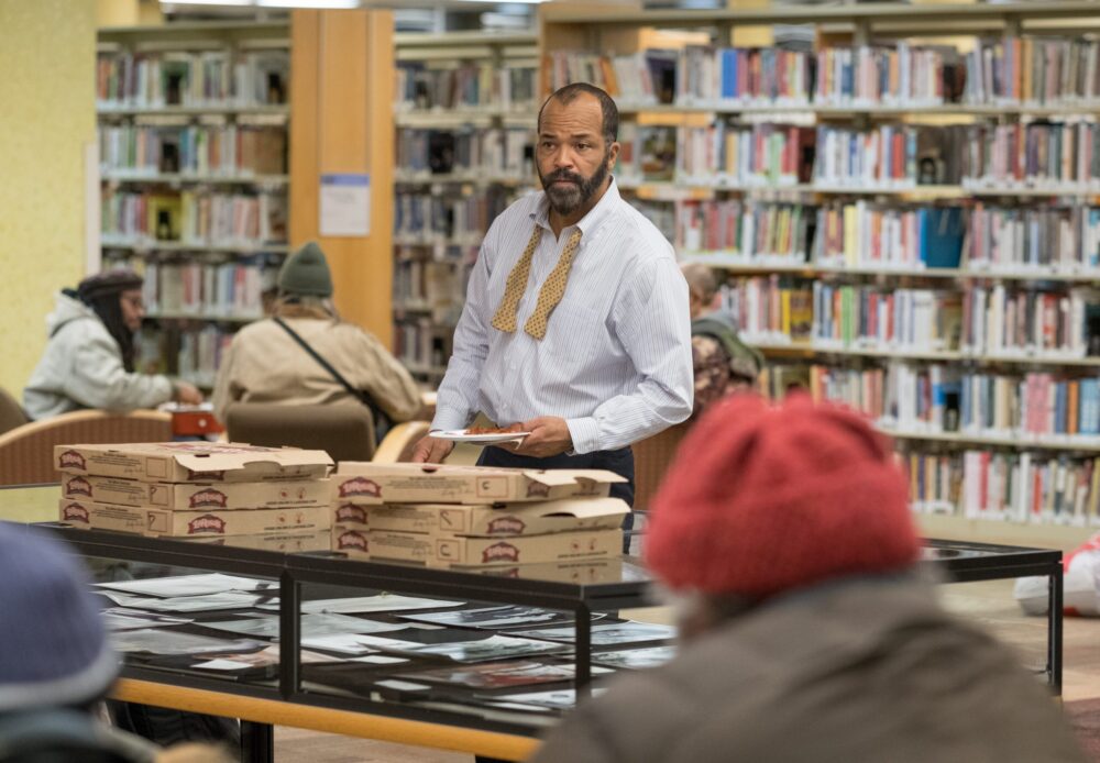 Jeffrey Wright in "The Public" offers pizza in a library.