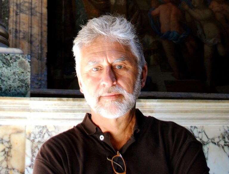Portrait of Paul Wagner, an older man with gray hair and beard, wearing a brown polo shirt.