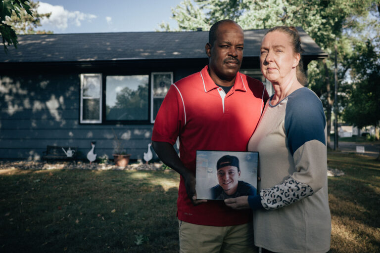 Parents holding photo of son, a tribute following a death.