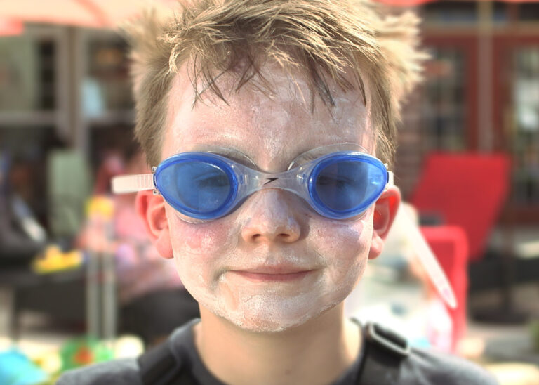 Boy with sunscreen and blue goggles on his face