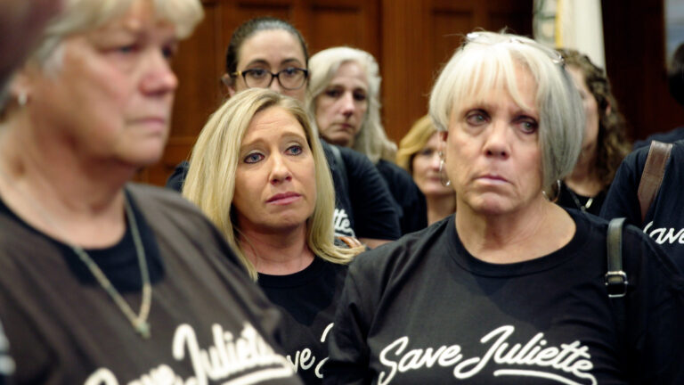 Group wearing "Save Juliette" shirts, serious expressions.