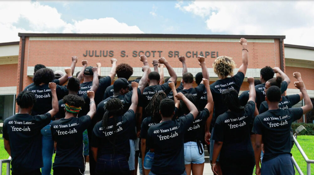 HBCU students protesting Confederate monuments, raising fists. Shirts read "400 Years Later...free-ish.