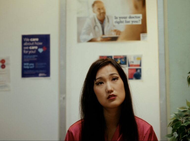 Teen girl in a doctor's office waiting room. Medical posters on the wall.