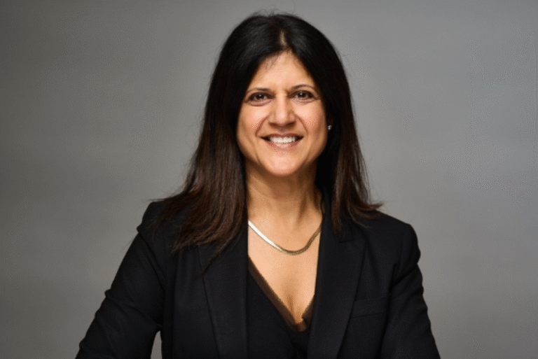 Irma Shrivastava, smiling in a professional headshot wearing a black blazer.