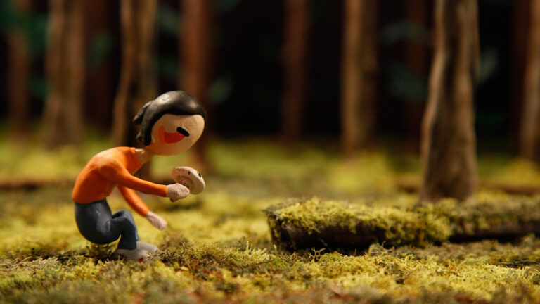 Clay figure in a pine forest holding a mushroom, fitting the theme "In the Shadow of the Pines.