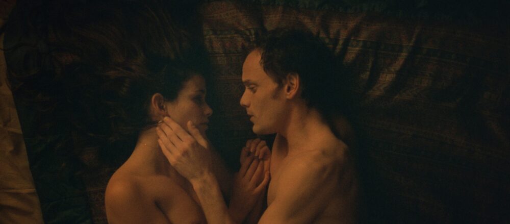 Couple lying in bed, intimate moment.
