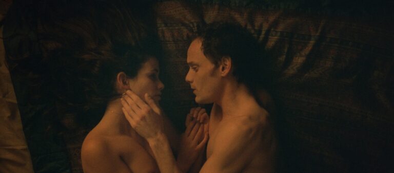 Couple lying in bed, intimate moment.
