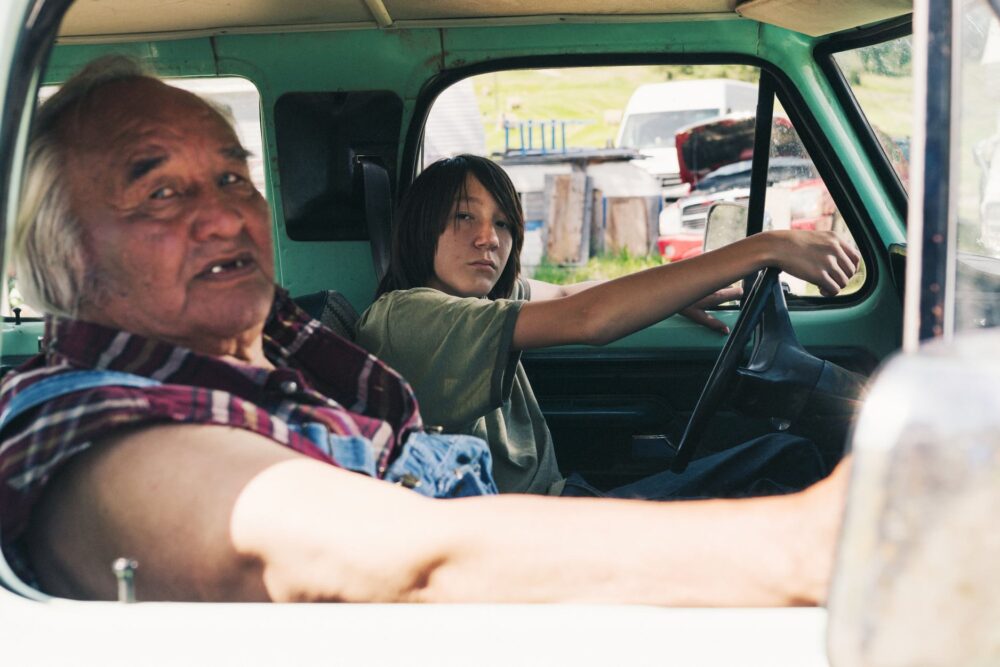 Elderly man and young person in a vintage truck. Portraits From a Fire.