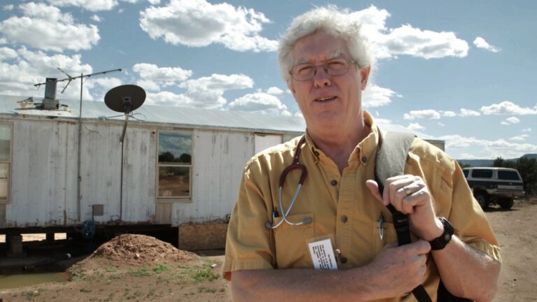 The Providers: Doctor with stethoscope outside rural clinic.